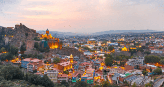 Evening lights over Tbilisi’s historic buildings during Jugni’s Georgia group tour for solo women travelers — cityscape glowing with charm and culture.