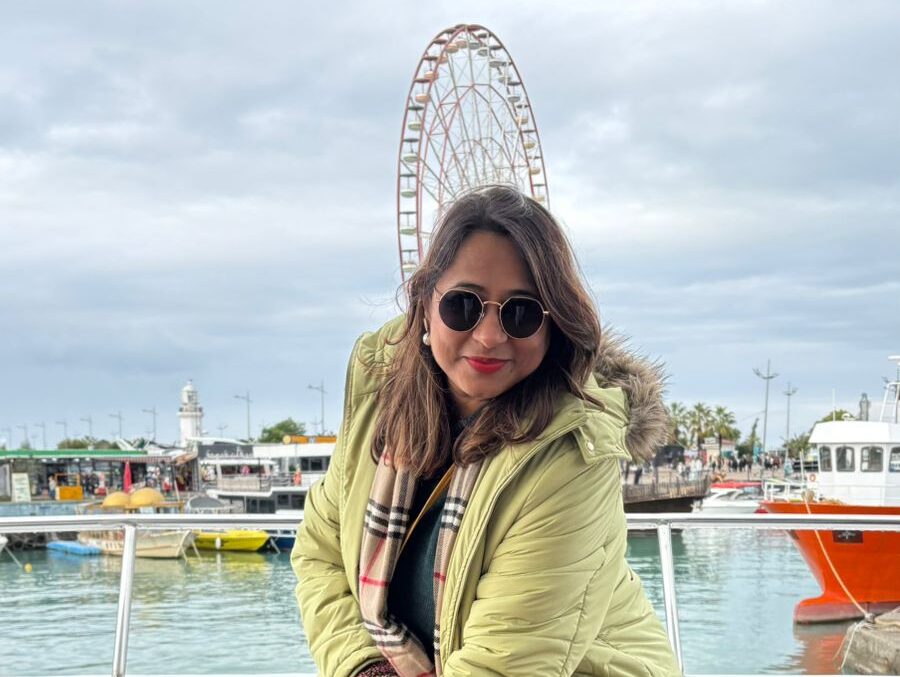 Shivranjini on a Jugni trip smiling in front of a ferris wheel in Europe – a solo traveler’s joy