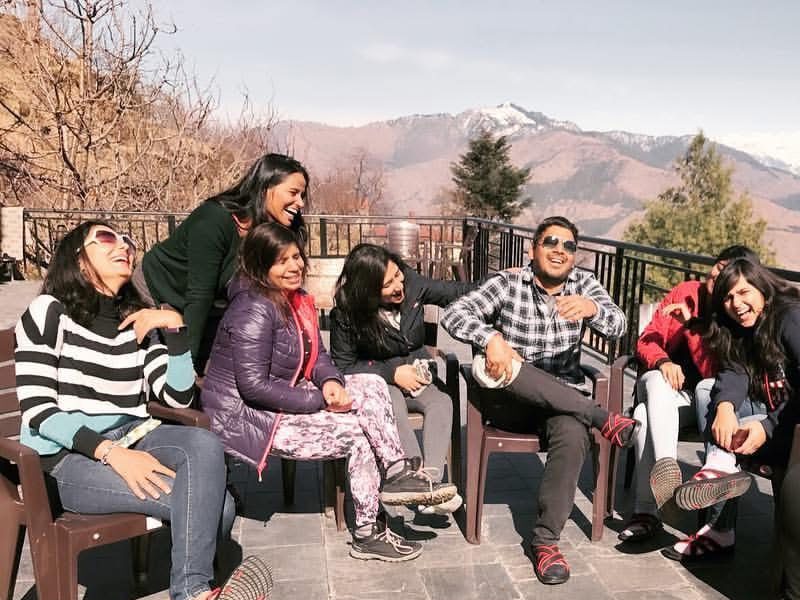 Nitesh Chauhan, founder of Jugni Travel, making women travellers laugh during a sunny morning at Deodar Cottage, Himachal Pradesh — a moment of pure joy and connection on a women-only weekend getaway.